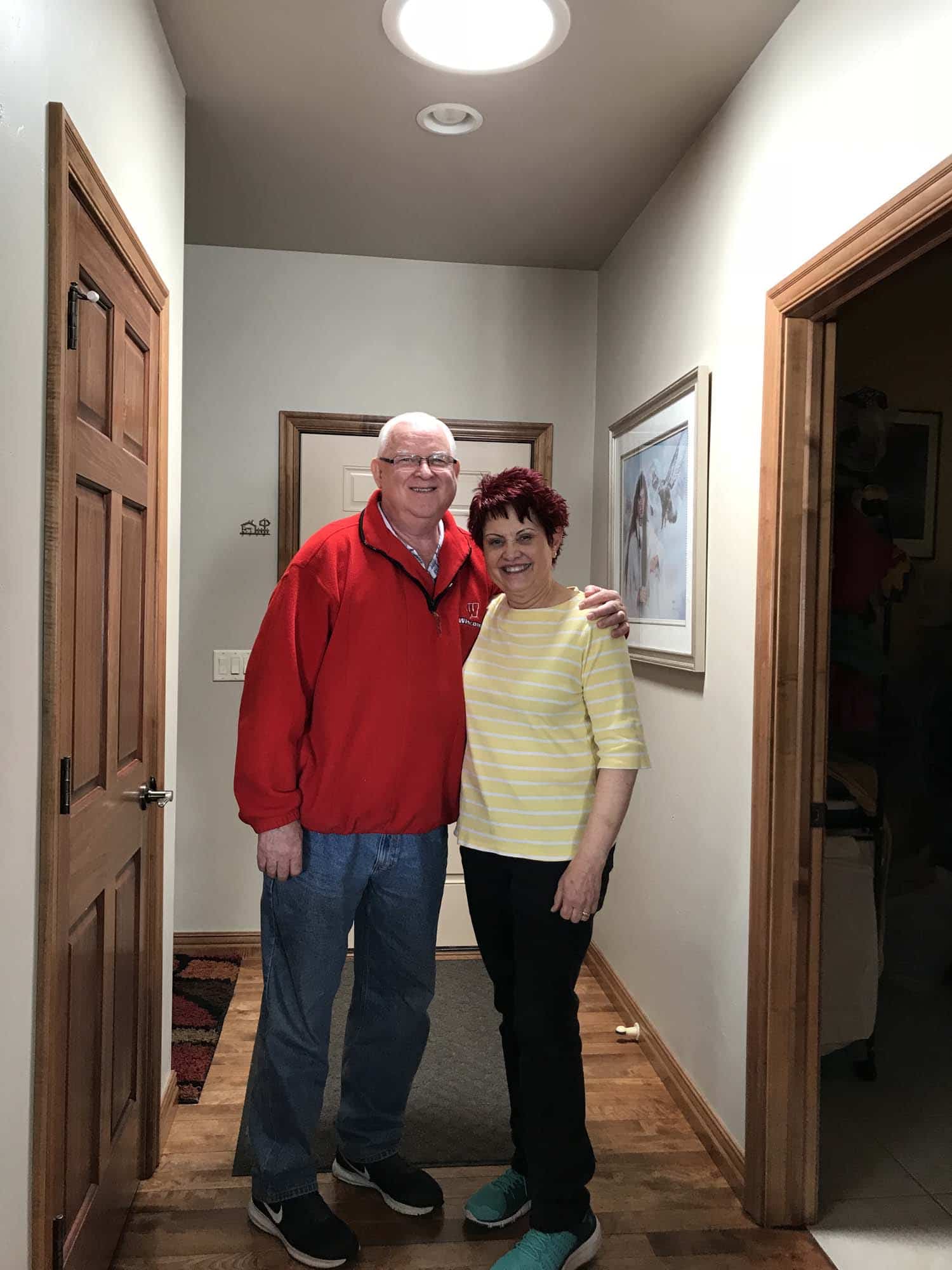 Husband & wife pose for a photo underneath their brand new VELUX skylight installed by Wisconsin Sunlight Solutions.